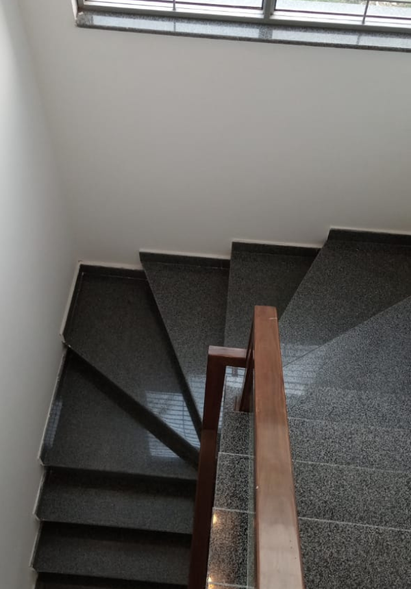 Granite staircase with wooden handrail in 5 marla house in DHA Lahore