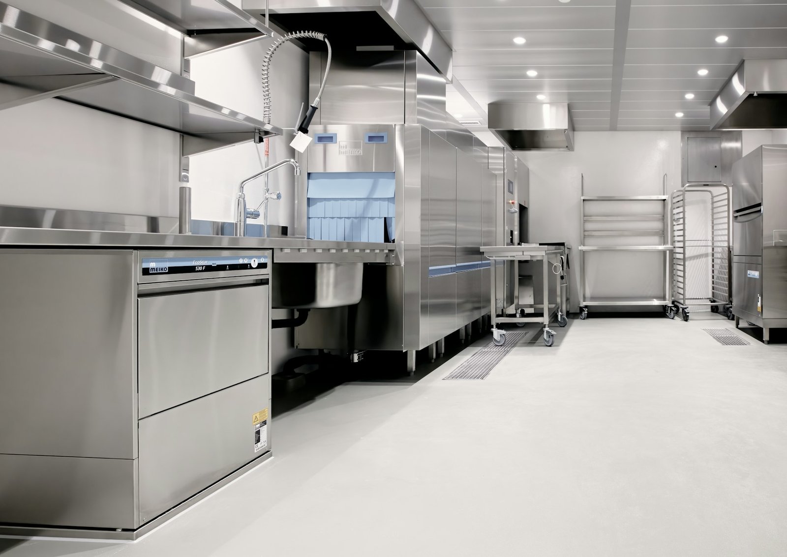 Commercial kitchen design with stainless steel cooking line and exhaust hood
