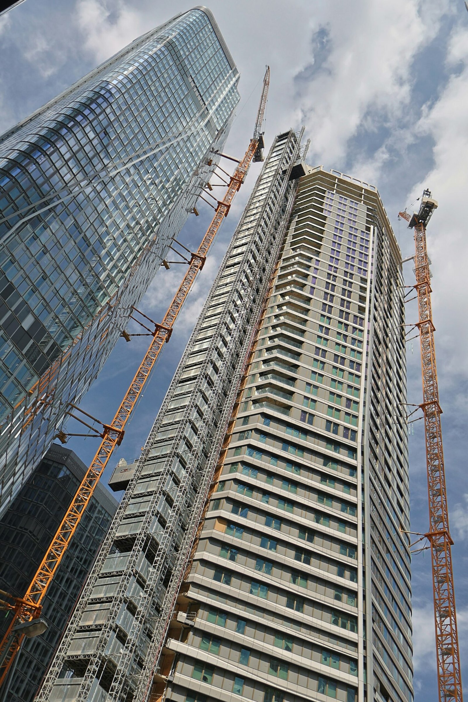 High-rise apartment tower under construction with tower cranes