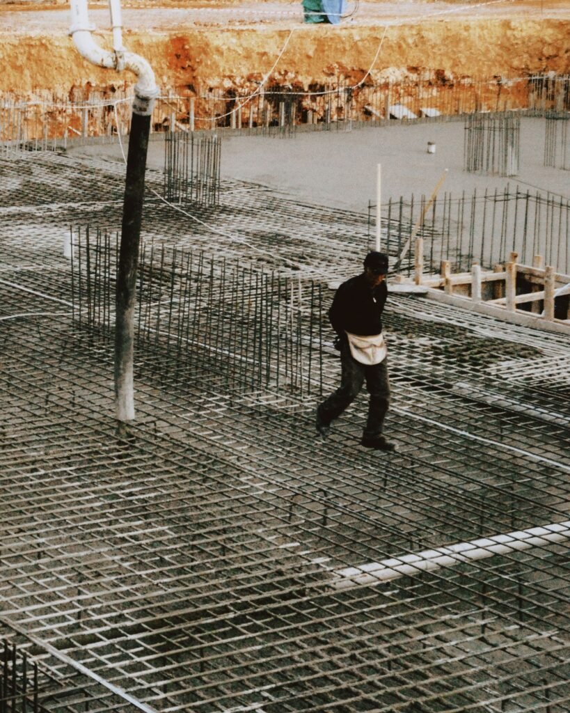 Worker on steel rebar slab reinforcement before concrete pouring