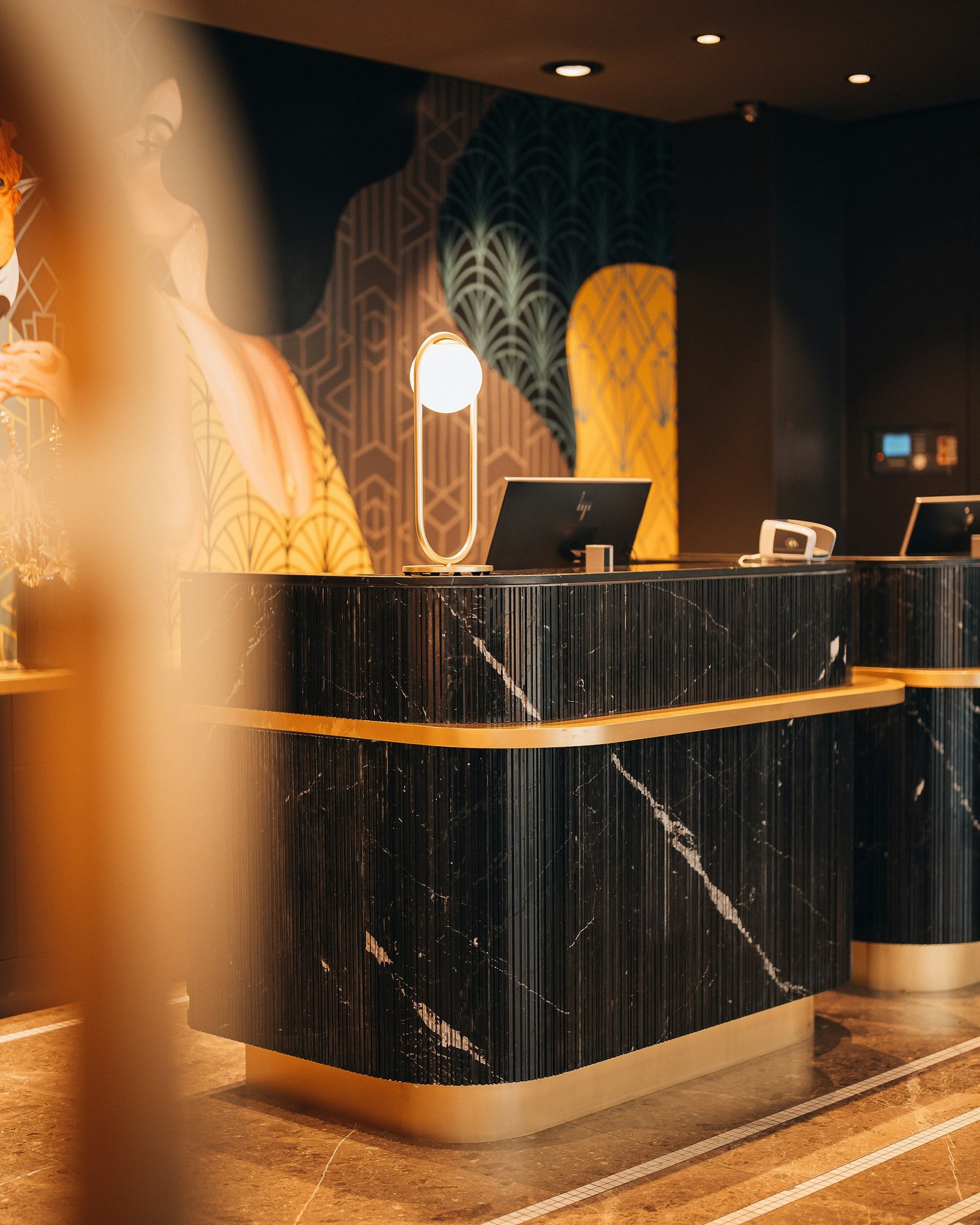 Reception desk design in black marble with gold trim
