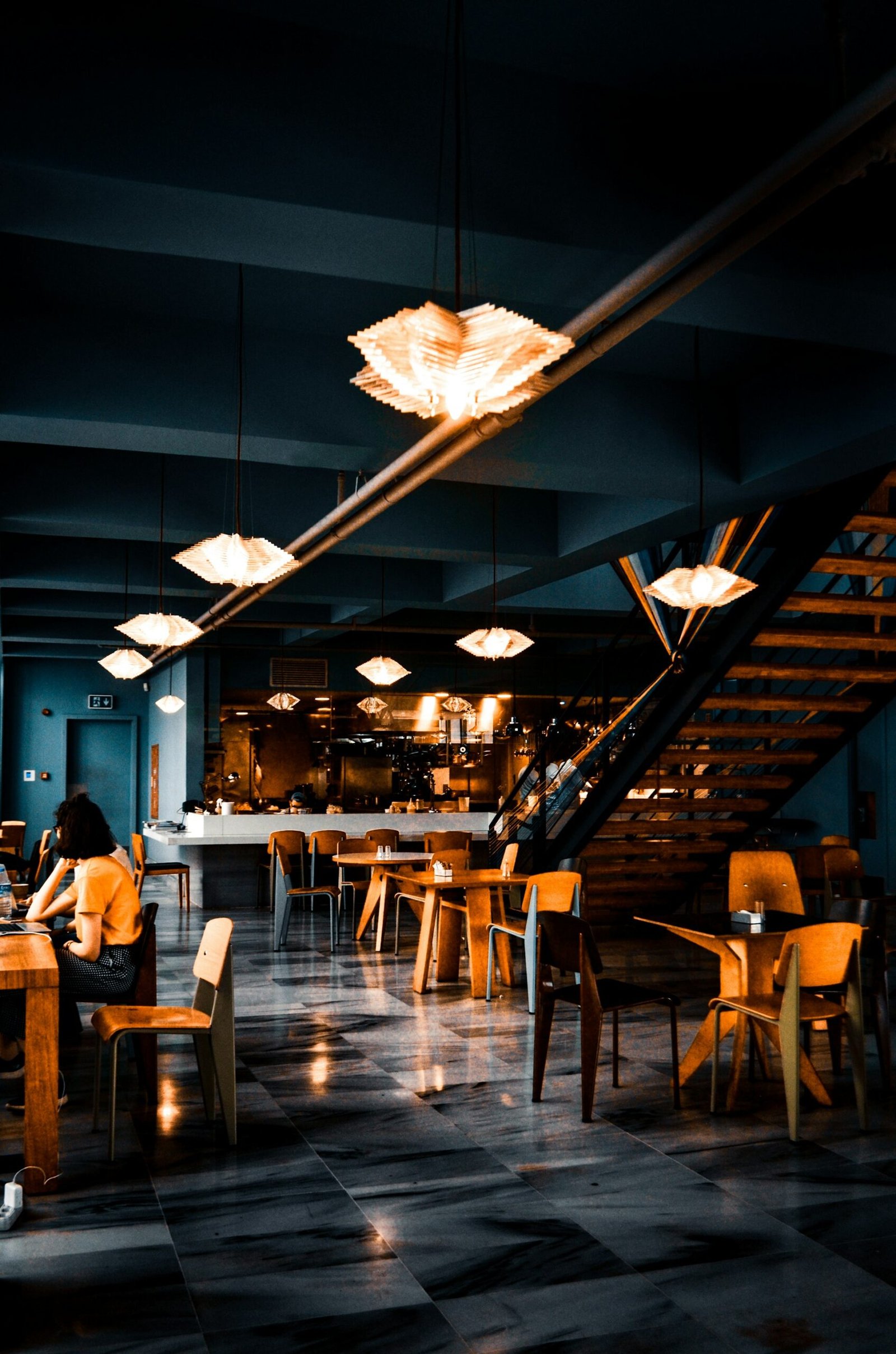 Modern restaurant interior design with pendant lighting and an open staircase