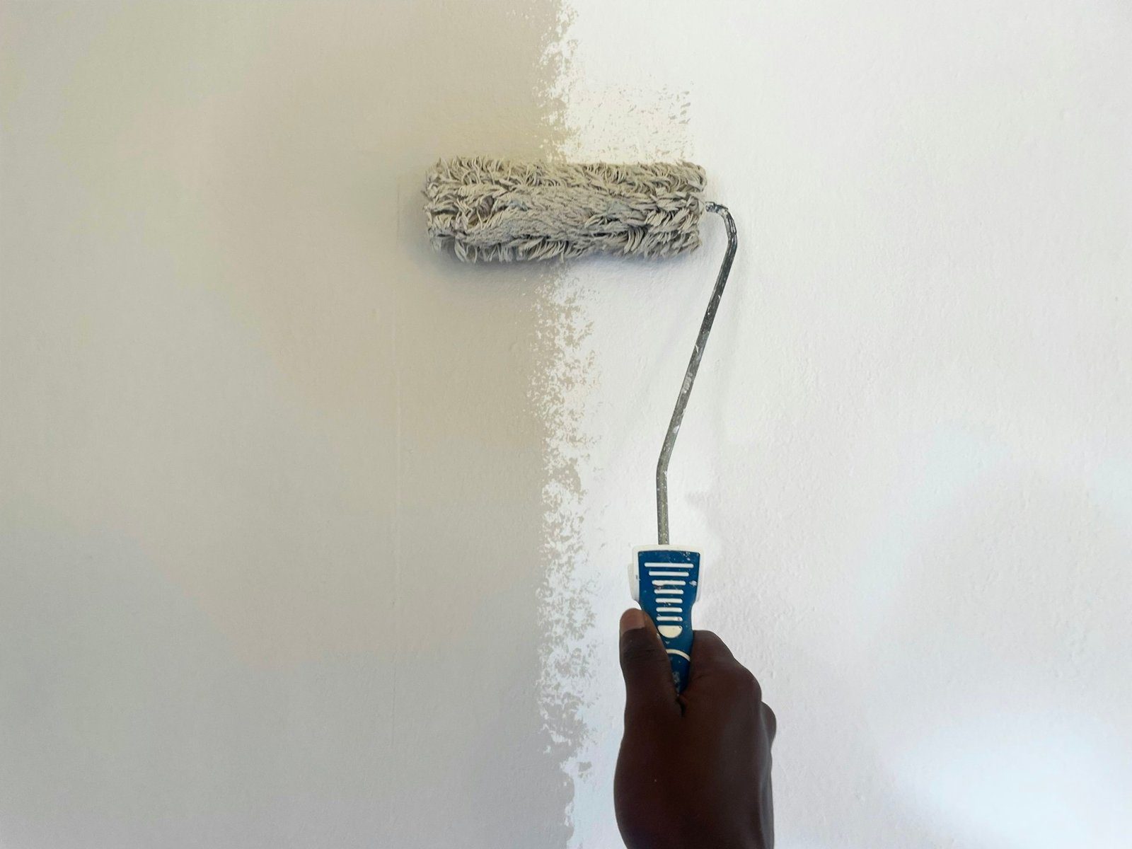 Wall painting with roller during house renovation